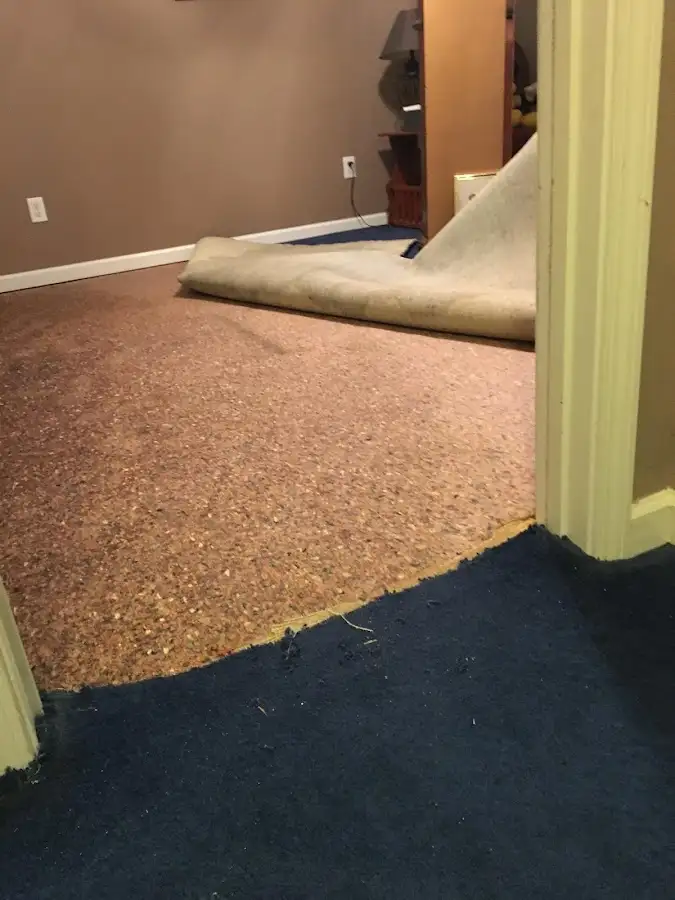 Carpet pad removal revealing water damage during Water Mitigation Services in College Station